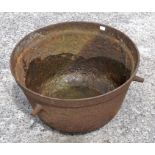 A metal cauldron with three handles,