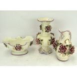 Three pieces of ornate ceramics, each adorned with floral decoration, comprising jug,