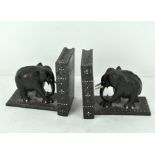 A pair of carved Sri Lankan ebony and bone inlaid book ends, in the form of elephants,