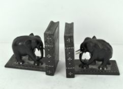 A pair of carved Sri Lankan ebony and bone inlaid book ends, in the form of elephants,