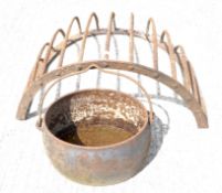 A metal hanging hay basket and a metal cauldron with swing handle,