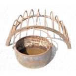 A metal hanging hay basket and a metal cauldron with swing handle,