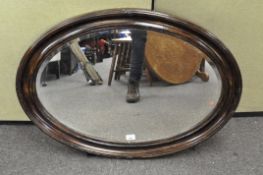 A large 19th century bevelled edge mirror, of oval form,