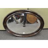 A large 19th century bevelled edge mirror, of oval form,