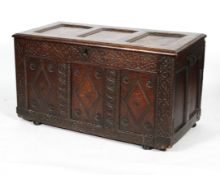 A late 17th century oak coffer, the triple panelled top enclosing a vacant interior,