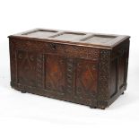 A late 17th century oak coffer, the triple panelled top enclosing a vacant interior,