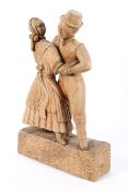 A carved wood sculpture of two dancers, a man and woman in 19th century dress,