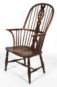 An ash and elm Windsor chair, with crinoline stretcher, carved wheel splat, flanked by spindles,
