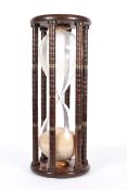 A large vintage hourglass timer, with brass mounted column supports,