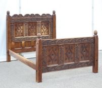 A Wood Carvers Guild Double Bed, the head and foot boards carved with floral and foliate decoration,