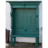 A large green painted garden seat, carved with acanthus and lion masks,