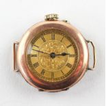 A rose and yellow metal cased watch. Circular gold dial with roman numerals and engraved design.