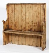 A Victorian pine settle, with tongue and grooved back and scrolled arms,
