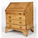 A stripped pine bureau, the fall front enclosing a fitted interior above three long drawers,