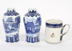 A pair of Chinese porcelain baluster blue and white vases decorated with a scene of a lakeside