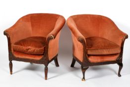 A matched pair of Edwardian tub chairs, each upholstered in salmon pink velvet, with scroll arms,