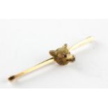 A yellow metal bar brooch, having a central fox head of textured finish and set with cabochon eyes.
