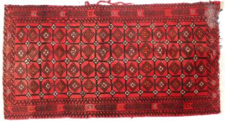 An Afghan Turkmen style rug with a trellis and lozenge design inside floral borders,