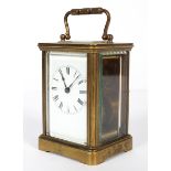 A French brass carriage clock, with white enamelled dial and black Roman numerals,
