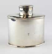 An Edwardian silver tea caddy of oval form, the borders with reeded decoration,