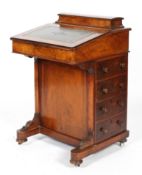 A Victorian walnut davenport, the hinged stationery box above a leather inset slope,