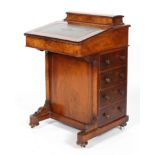 A Victorian walnut davenport, the hinged stationery box above a leather inset slope,