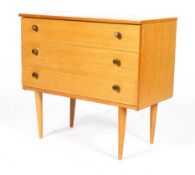 A Schreiber mid century teak chest of three long drawers, with brass pulls, on tapering legs,