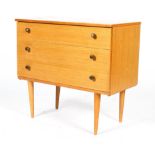 A Schreiber mid century teak chest of three long drawers, with brass pulls, on tapering legs,