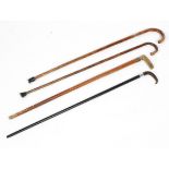 A collection of four silver mounted walking sticks, two in bamboo, two with horn handles,