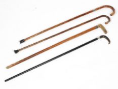A collection of four silver mounted walking sticks, two in bamboo, two with horn handles,