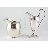 A silver cream jug, of slightly swollen form with chased decoration and a crest beneath the spout,
