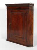 An 18th century oak corner cupboard, with moulded cornice and panelled door,