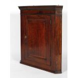 An 18th century oak corner cupboard, with moulded cornice and panelled door,