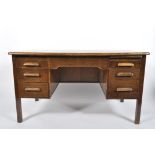 A mid century oak twin pedestal desk, with an arrangement of seven drawers around the kneehole,