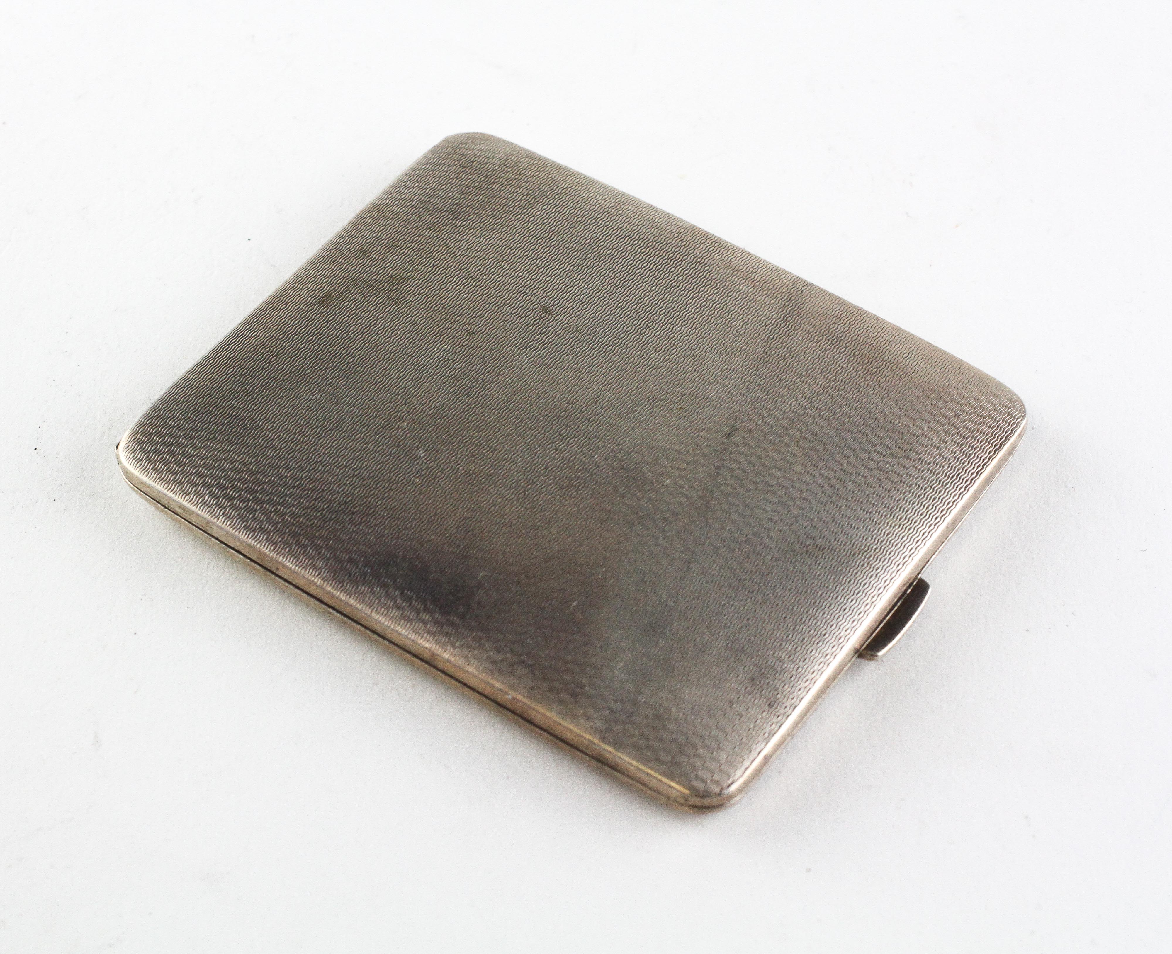 A silver cigarette case of rectangular form, engine turned decoration throughout,