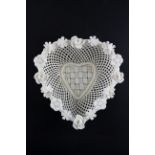 A Belleek heart shaped basket, four strand base, applied with flowers to the rim,