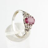 A white metal ring. Principally set with an oval faceted cut ruby stamped to weigh 1.00ct.