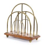 A vintage, mid 20th century brass and wooden-mounted magazine rack, stamped WR & S below a sunburst,