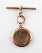 A rose metal circular locket pendant with attached heavy weight T bar. Hallmarked 9ct gold.