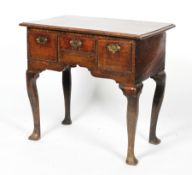 A Georgian oak lowboy, with two deep drawers flanking a central slim drawer, on cabriole legs,