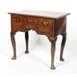 A Georgian oak lowboy, with two deep drawers flanking a central slim drawer, on cabriole legs,