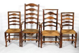 A group of four assorted oak ladder back chairs, including two carvers, with rush seats,