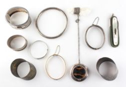 A collection of items to include: Three silver bangles; A rolled gold bangle;
