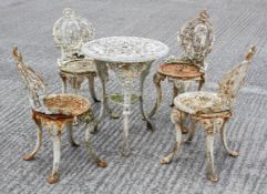A Victorian style cast iron patio set comprising four chairs and a circular table,