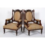 A pair of late Victorian armchairs, with upholstered back, arm rests and seat,