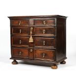 A Carolean style oak chest of drawers, with panelled front and drop brass handles,