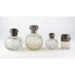 Three Edwardian silver topped cut-glass scent bottles and stoppers, each of globular form,