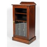 An Edwardian mahogany music cabinet, with raised back and glazed door,