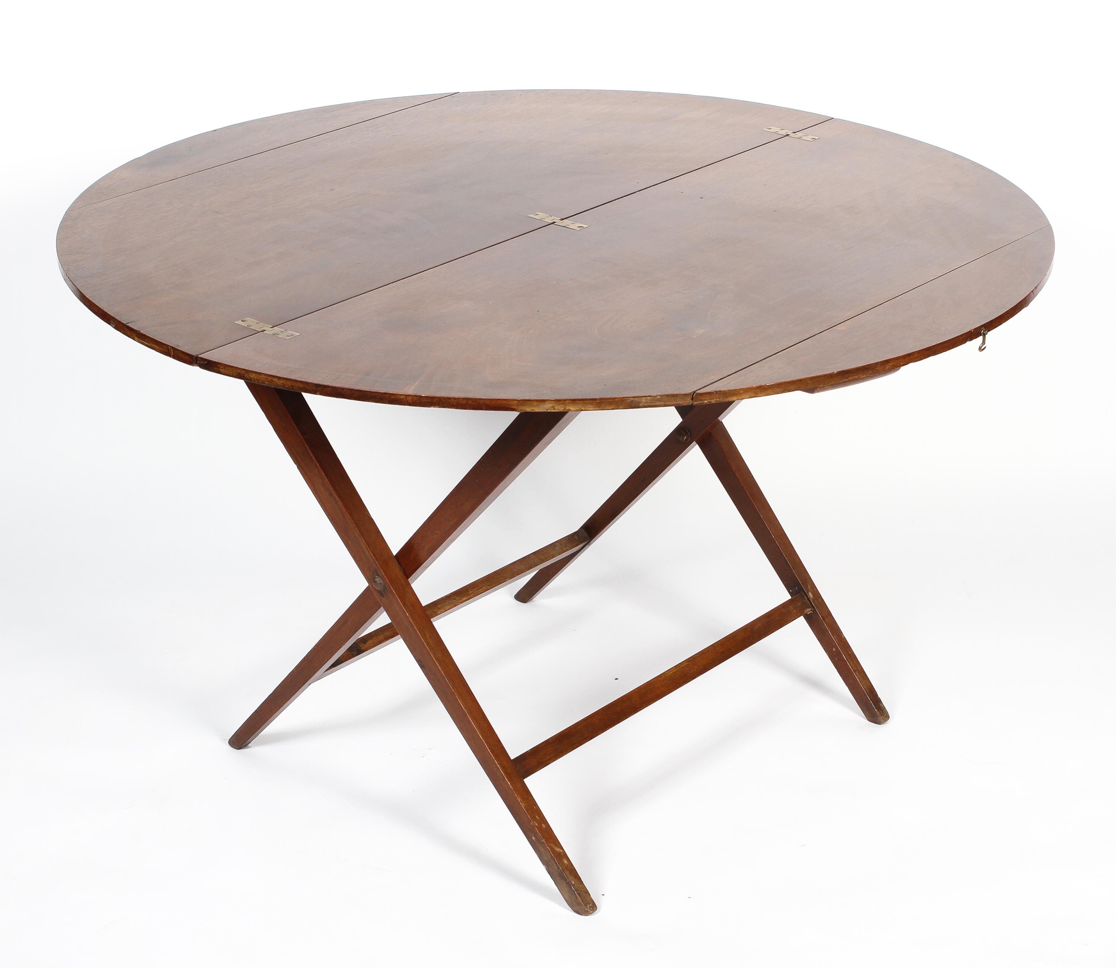 A Victorian mahogany coaching table, the circular top on a folding X frame, 60cm high,