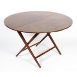 A Victorian mahogany coaching table, the circular top on a folding X frame, 60cm high,